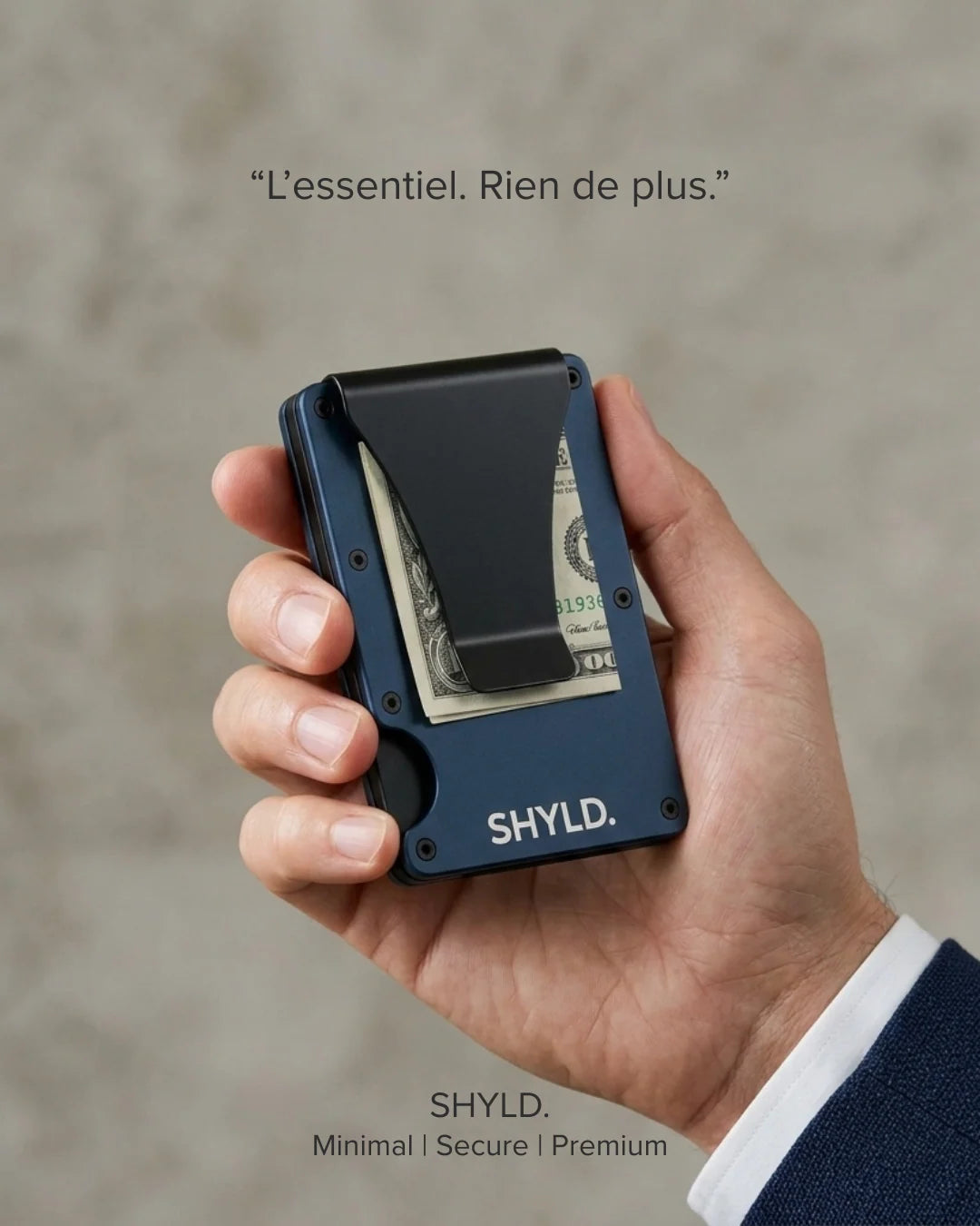 Homme tenant le porte-cartes minimaliste SHYLD en aluminium bleu marine, pince à billets visible